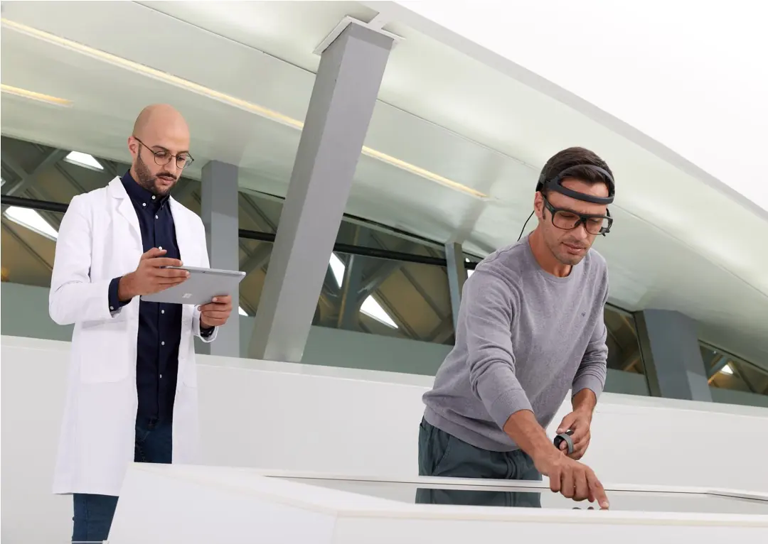 Participant wearing an EEG headband and eye-tracking glasses beside a researcher
