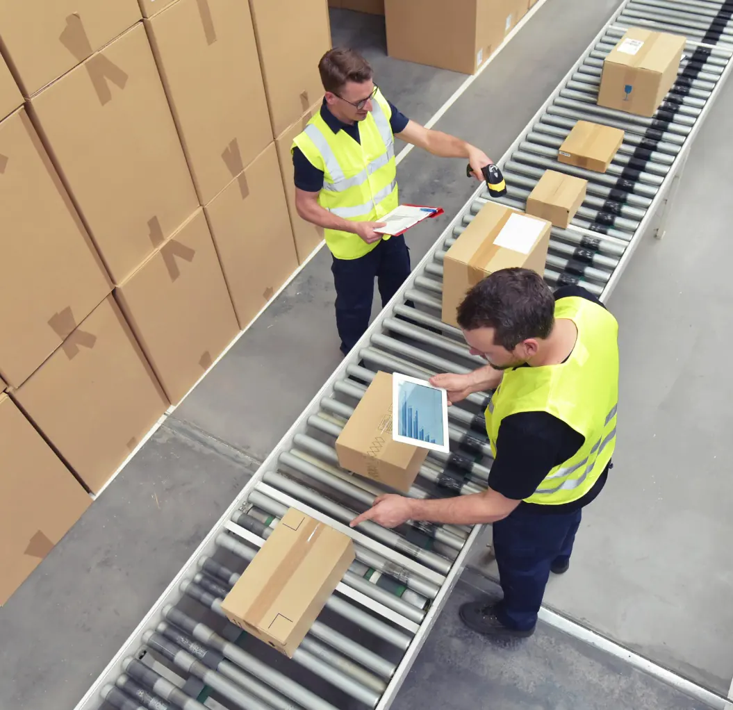 Workers handling parcels on a logistics conveyor