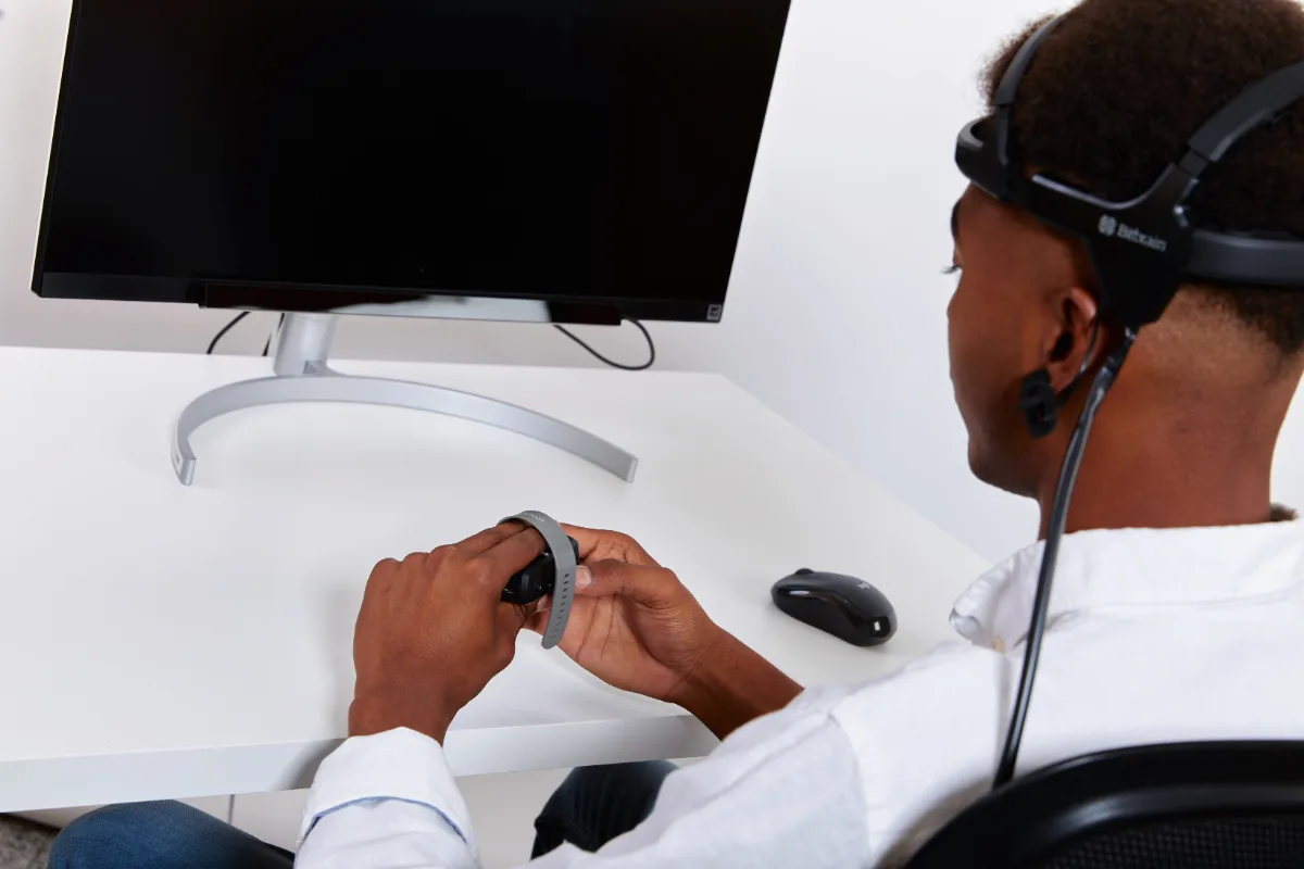 Participant wearing Bitbrain Air EEG and Ring in front of a screen-based Tobii eye tracker