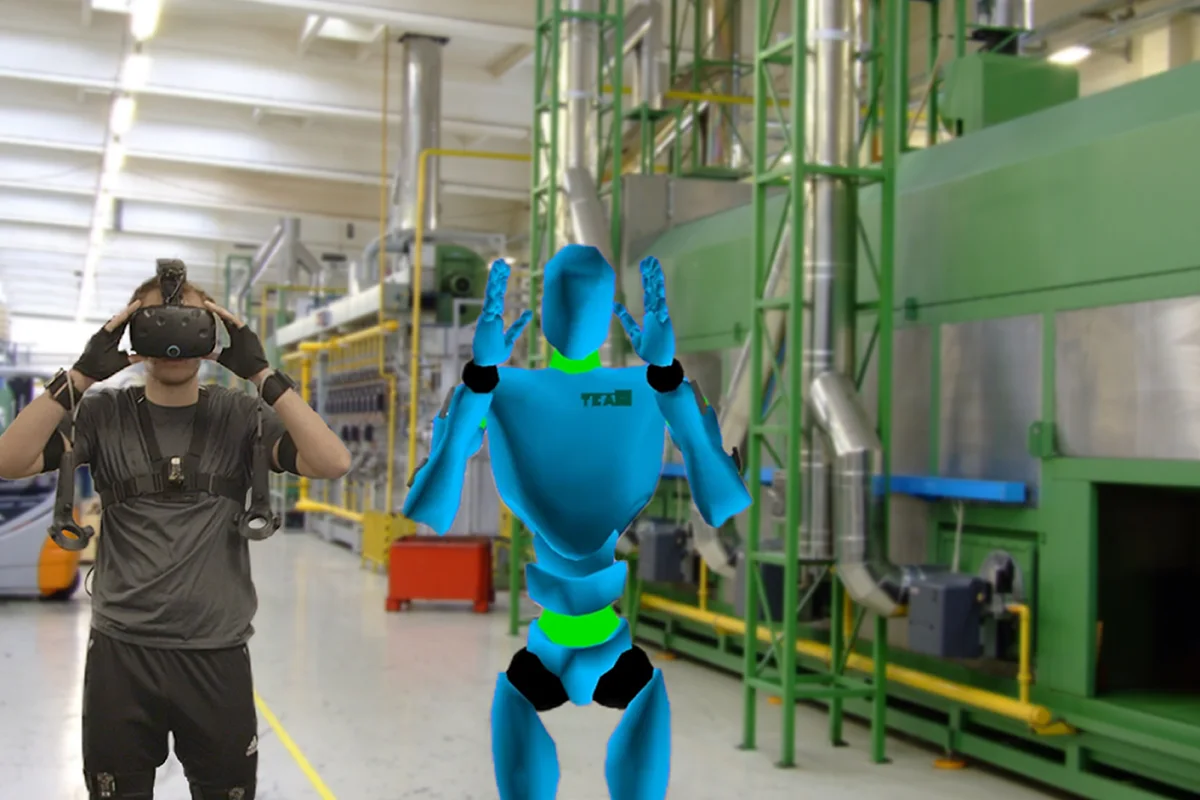 Worker in a VR headset beside a live avatar of his posture in a factory
